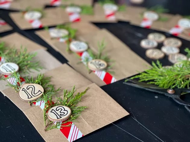 paper bag envelopes decorated with wood slices, greenery and wrapping paper