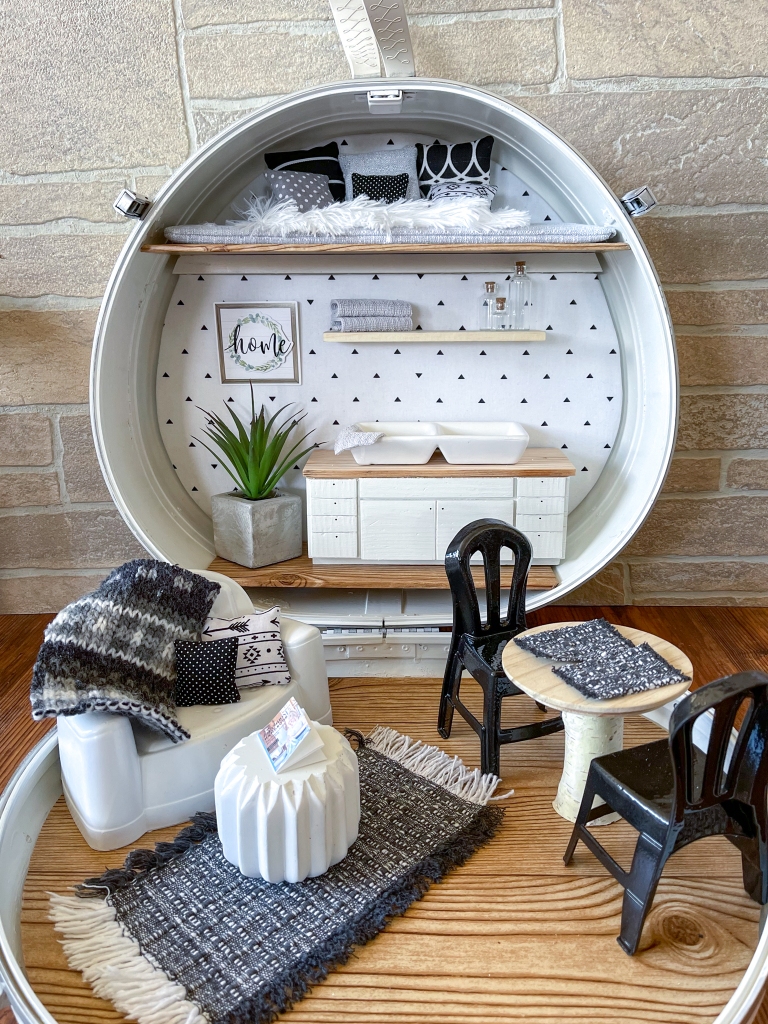 Vertical close up of a dollhouse made from a vintage suitcas