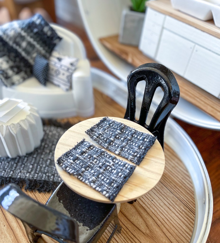 close up of a miniature table made from a wooden candle lid and a branch with tiny placemats