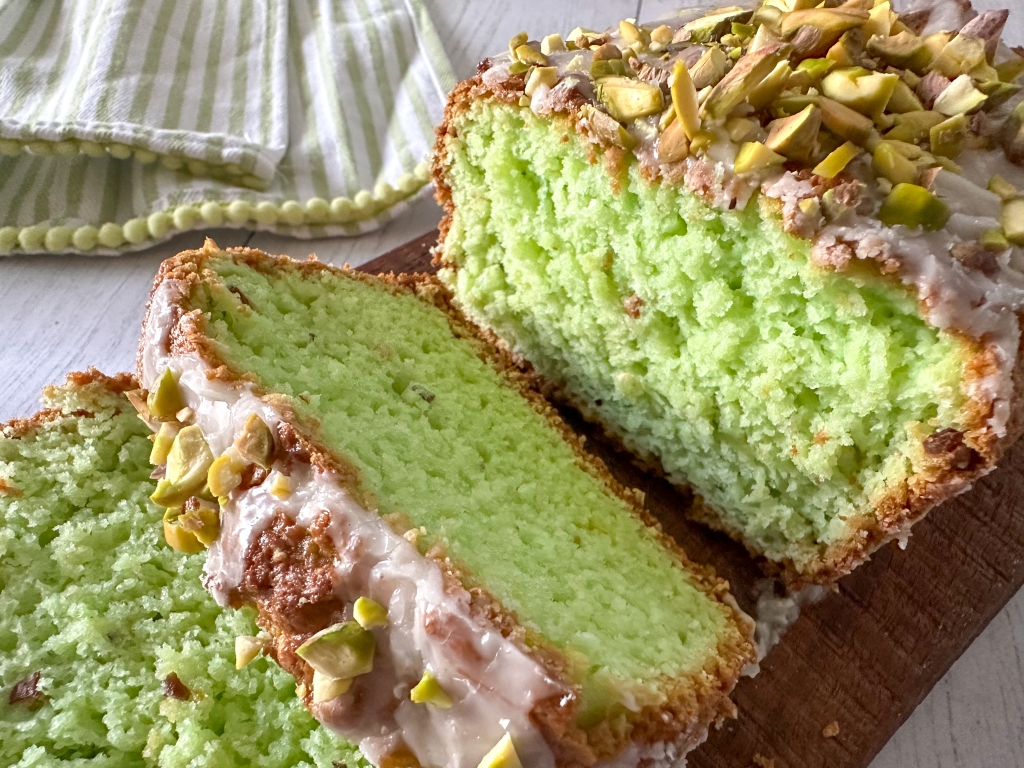 Sliced green homemade pistachio bread on a cutting board