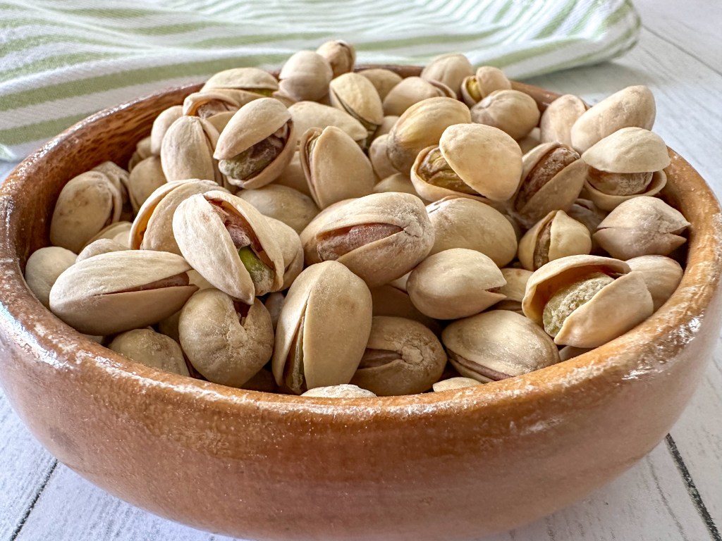 wooden bowl filled with pistachios